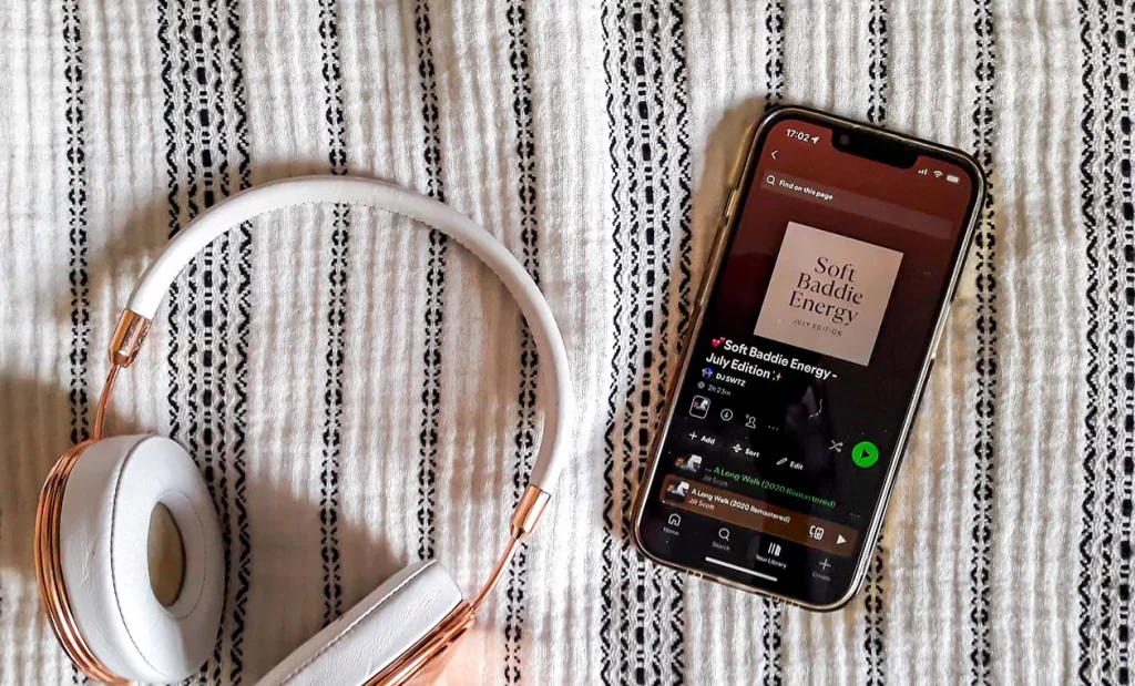 Overhead shot of a phone and headphones on a soft throw blanket